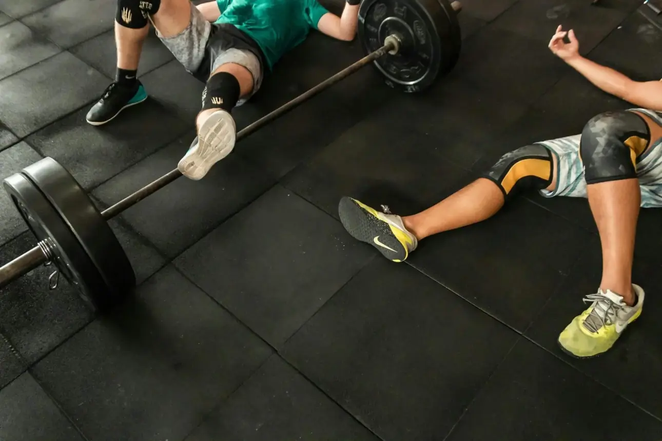 Deux personnes en tenue de sport, allongées lors d’un entraînement de CrossFit — image de motivation fitness et de transformation physique, symbole de santé, de bien-être, d’entraînement intensif et de potentiel de changement de vie.