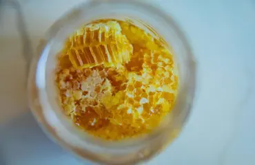 Sélection de différents miels — pots et cuillères en bois, mise en avant de la teneur en sucres naturels, minéraux, bénéfices santé et bienfaits nutritionnels pour régime équilibré ou alimentation fitness