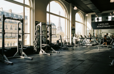 Salle de sport moderne avec vue sur la Tour Eiffel à Paris.
