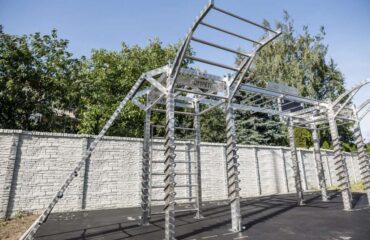 Structure métallique de street workout extérieure sous ciel bleu.