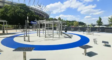 Parc de fitness extérieur moderne sous ciel bleu près d'un stade.
