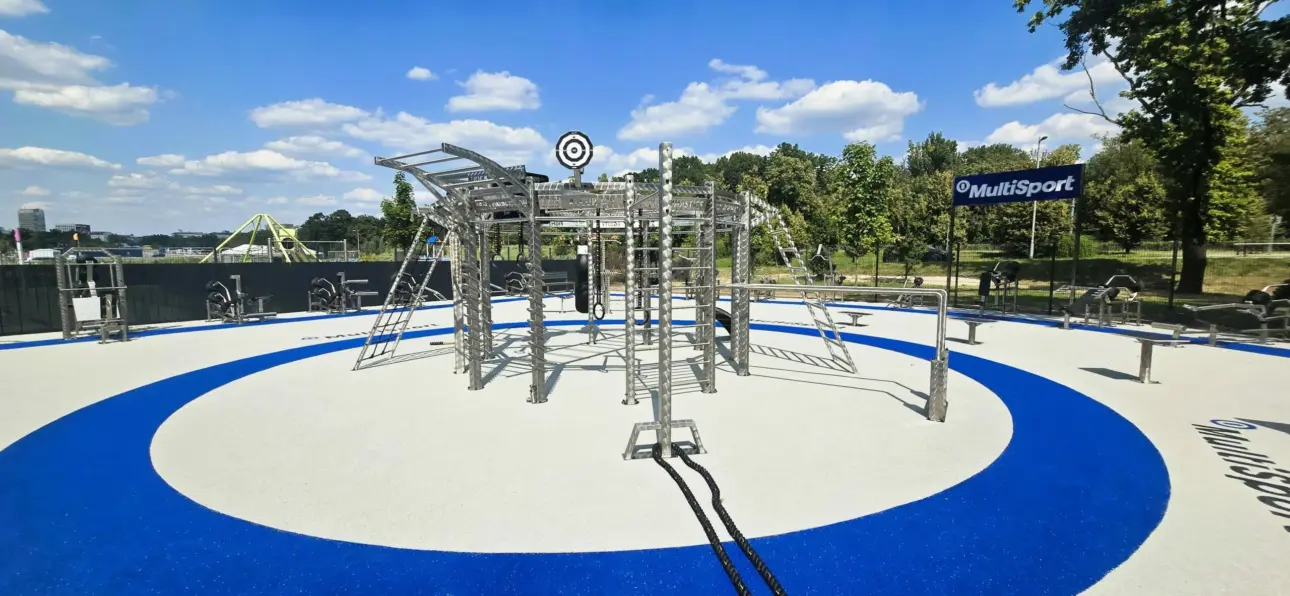 Parc de fitness extérieur moderne sous un ciel bleu ensoleillé.