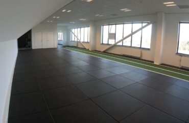 comment poser des dalles caoutchouc dans une salle de sport pose libre ou collée, étape par étape Salle de sport moderne avec tapis noir et piste verte