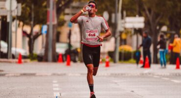 Coureur buvant, eau éclaboussant, course sur route mouillée, effort.