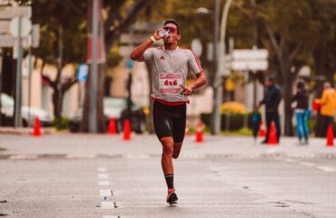 les comparatifs essentiels pour les sportifs équipement, nutrition, hydratation et récupération Coureur buvant, eau éclaboussant, course sur route mouillée, effort.