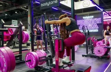 Femmes s'entraînant dans une salle de sport avec des appareils roses Bodytone.