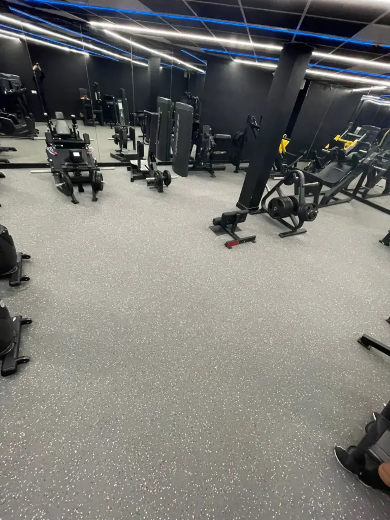 Sol en dalles puzzle caoutchouc gris clair moucheté dans une salle de musculation