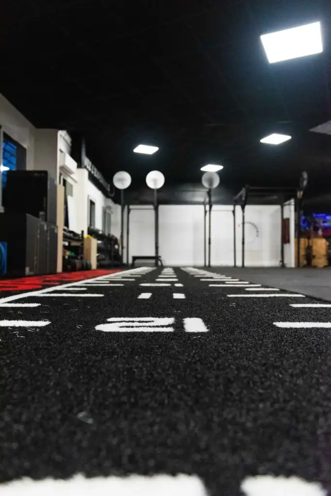 Piste en gazon synthétique noire graduée vue au ras du sol dans une salle d’entraînement